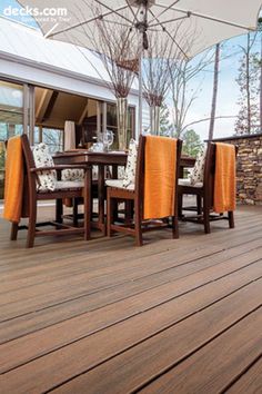 an outdoor dining area with wooden flooring and umbrella