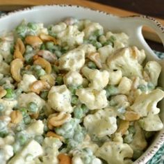 a white bowl filled with pasta and peas