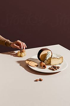 a person sitting at a table with a plate of cheese and crackers on it