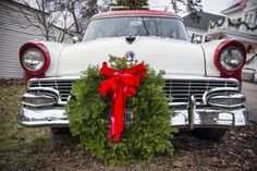 an old car with a christmas wreath on the front