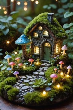 a small fairy house in the middle of a garden with lights and mushrooms around it