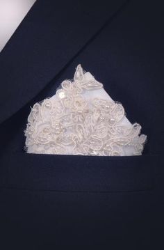 a close up of a white wedding garter on a man's lapel