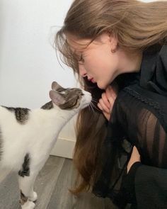 a woman is petting a cat on the nose