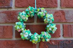 an origami wreath hanging on a brick wall