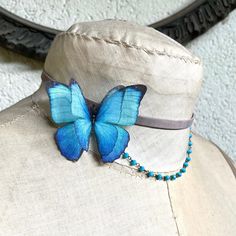 a blue butterfly sitting on the back of a white mannequin's head