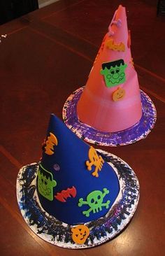 two paper hats sitting on top of a wooden table