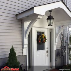 a white front door with a lantern and wreath on the side entrance to a house