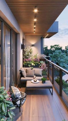 a balcony with couches, tables and plants on the outside deck overlooking the trees