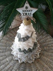 a christmas tree ornament sitting on top of a wicker table next to a palm tree