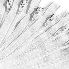 several white zippers are lined up in rows on a white background with clippings