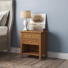 a night stand with two drawers and a lamp next to it on a hardwood floor