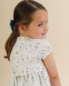 Our bestselling Shirley dress, crafted from lightweight pastel-coloured floral cotton, is a must-have for your little one's wardrobe. The dress features exquisite hand-smocking and embroidery across the bodice, complemented by decorative mother-of-pearl buttons. Designed with a charming Peter Pan collar and short puff sleeves, this fully lined dress fastens at the back with delicate mother-of-pearl buttons and a button-fastening sash, creating a deluxe silhouette. Pair it with our iconic Mary Ja Cute Daywear Dresses With Buttons, Cotton Dresses With Buttons For Garden Party, Cotton Dress With Buttons For Garden Party, Baby Boy Shirts, Girls Special Occasion Dresses, Hand Smock, Christening Gowns, Peter Pan Collar, Mother Of Pearl Buttons