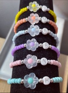 a stack of bracelets sitting on top of a black piece of cloth covered in beads