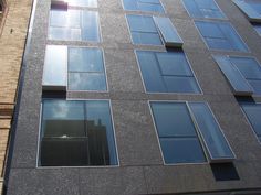 a tall building with lots of windows on it's side and a clock tower in the background