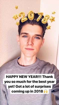 a young man wearing a happy new year t - shirt with gold stars on his head