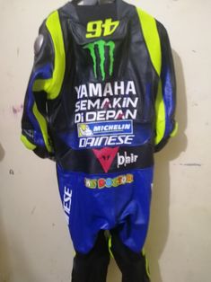 a blue and yellow leather motorcycle suit with the words yamaha on it's chest