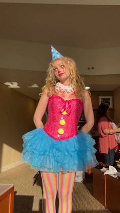 a woman in a clown costume is standing with her hands on her hips