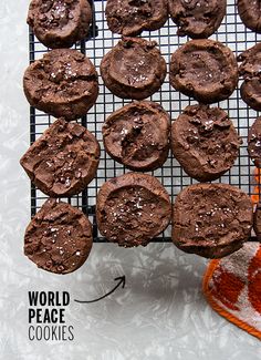 chocolate cookies on a cooling rack with the words world peace cookies below it and an orange mitt next to them