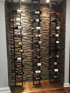 a wine rack in the corner of a room with wood flooring and stone walls