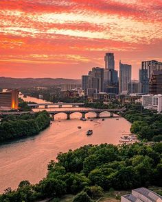 the sun sets over a city and river