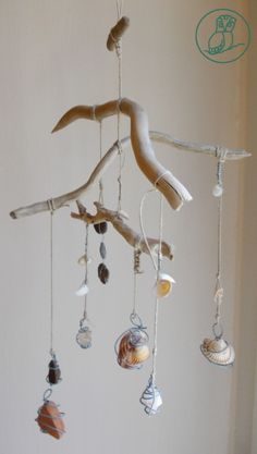 a mobile made out of driftwood and seashells hanging from it's ceiling