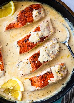 salmon with sauce and lemon slices in a skillet