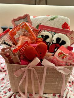 a basket filled with lots of toys on top of a bed