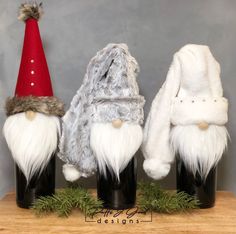 three gnomes sitting on top of each other in black vases with white fur