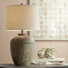 a table with a lamp on top of it and a book sitting next to it