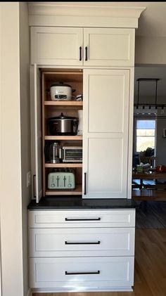 a kitchen with white cabinets and black counter tops