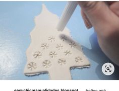 someone is making a snowflake ornament out of white clay and glue