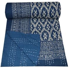 the blue and white blanket is folded on top of each other with an intricate design