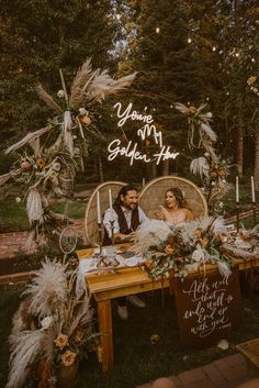 a bride and groom sitting on a wicker chair at their wedding table with the words you're my golden year above them