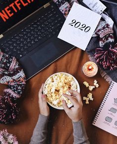 someone is eating popcorn and watching netflix on their laptop