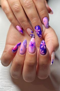 These almond-shaped nails are a vibrant celebration of purple hues. Some nails showcase beautiful gradient transitions from lilac to deep purple, while others are embellished with artistic white and purple floral patterns. A playful touch is added with a single heart and star design, creating a whimsical yet harmonious look. This manicure is a charming nod to the joyful spirit of spring! 🌸  // Photo Credit: Instagram @artbetweenthelines Lilac Nails Design, Purple And Pink Nails, Purple Glitter Nails, Funky Nail Art, Purple Nail Art, Lilac Nails, Purple Acrylic Nails, Purple Nail Designs, Lavender Nails