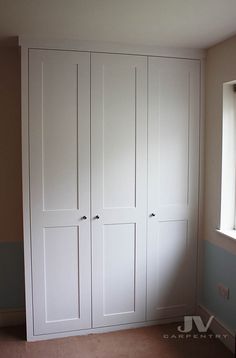 an empty room with white cupboards and carpeted floor