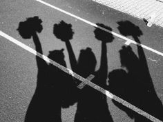 the shadow of three people holding up flowers