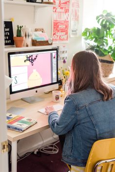 a woman sitting at a desk in front of a computer