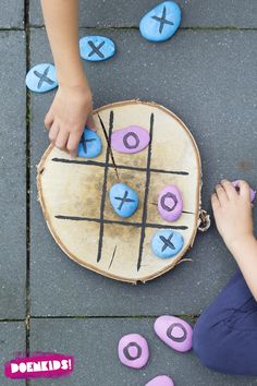 a child playing with an xo tic - tac toe game on the ground