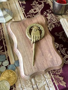 a wooden tray with a key on top of it next to some coins and other items