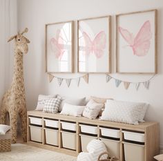 a room with some pictures on the wall and stuffed giraffe in the corner