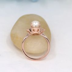 a pearl ring sitting on top of a rock