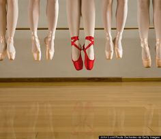 there are many pairs of ballet shoes hanging on the line with words be different above them