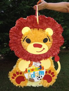 a lion pinata is being held up by someone's hand while holding the pinata