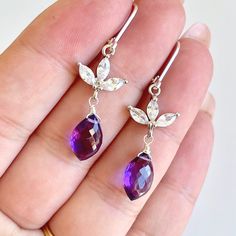 Amethyst Earrings, February Birthstone, Purple Teardrop Flower Earrings, Floral Drops Gold or Silver, Purple Jewelry, Valentine's Day Gift These simple but elegant earrings feature flawless faceted deep purple amethyst teardrops wire wrapped in your choice of gold filled or sterling silver. The purple teardrops are suspended from from a floral three petal white topaz flower element prong set in the finish of your choice. The earrings close with lever back ear wires. These earrings a adorable, ve Amethyst Properties, Amethyst Birthstone, Bridal Party Jewelry, Silver Gift Wrap, Purple Jewelry, February Birthstone, Valentines Jewelry, Amethyst Earrings, Silver Gifts