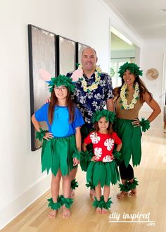 two adults and two children dressed up as hula dancers