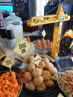 a table topped with lots of different types of food and signs that say dig in