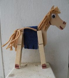 a wooden toy horse with braids on it's head sitting on top of a cement block