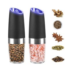 two salt and pepper shakers with spices in front of them on a white background