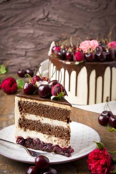 a slice of cake on a plate with cherries